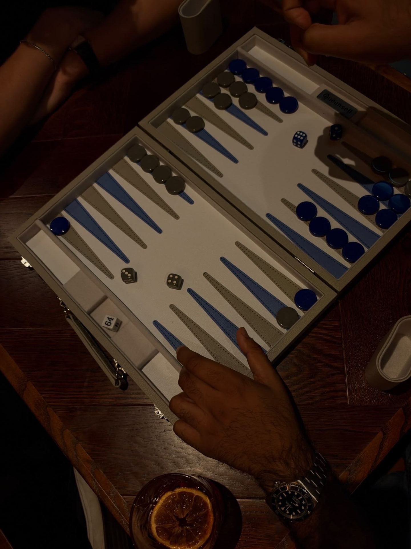 A backgammon game with blue checkers at a Backgammon & Wine event